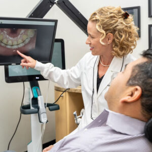 dentist showing patient images of teeth