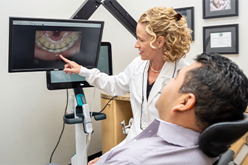 dentist showing patient images of teeth