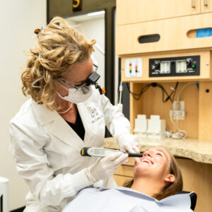 dentist working on patients teeth in dental chair
